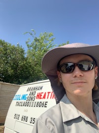 a man wearing a hat and sunglasses in front of a van